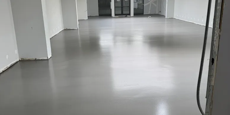 Seamless gray high-performance coating across a commercial interior floor