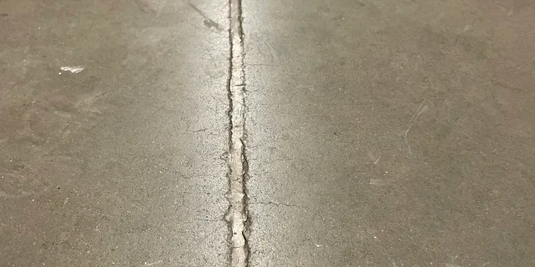 Close-up of a concrete slab joint being prepped for filler installation